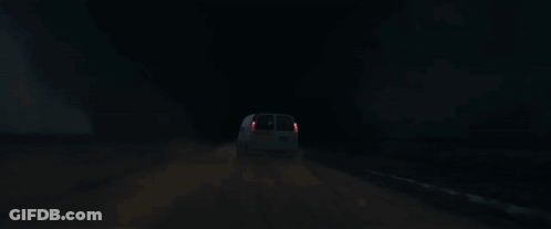 A White Van Is Driving Down A Road At Night With A Tornado In The Background GIF