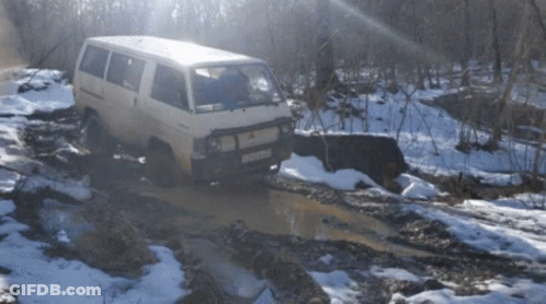 A White Van Is Driving Through A Muddy Puddle With A License Plate That Says Rc - 029 GIF