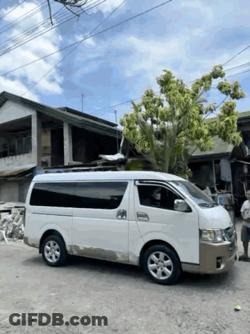 A White Van Is Parked In Front Of A Tree GIF
