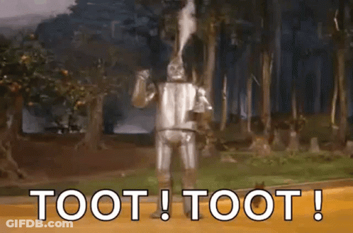 A Wizard Of Oz Character Is Standing In The Woods With The Words Toot ! Toot ! Above Him . GIF