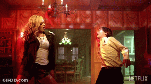 A Woman And A Boy Are Dancing In A Room With A Netflix Logo GIF
