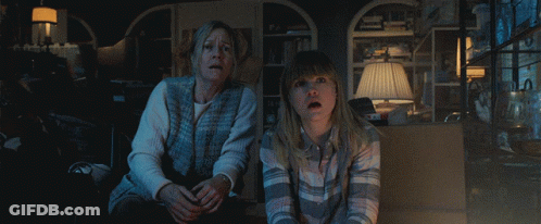 A Woman And A Girl Are Sitting In A Dark Room Looking At Something GIF