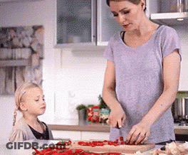 A Woman And A Little Girl Are Preparing Food In The Kitchen GIF