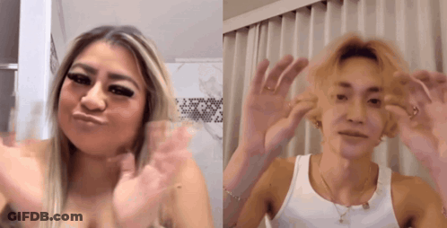 A Woman And A Man Are Waving Their Hands In Front Of A Window GIF