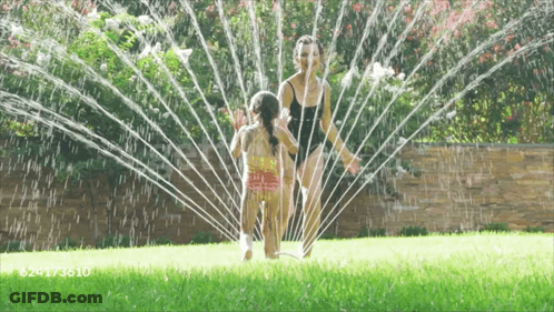 A Woman And Child Are Playing With A Sprinkler And The Number 624173610 Is On The Bottom GIF