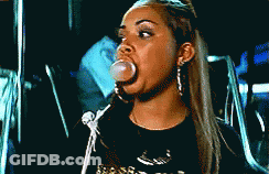 A Woman Blowing A Bubble With A Black Shirt On GIF