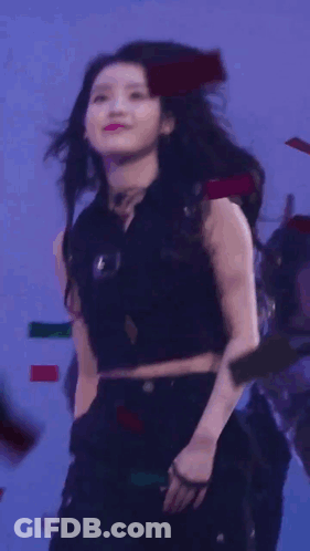 A Woman Blowing A Kiss While Holding A Microphone In Front Of Her Face GIF