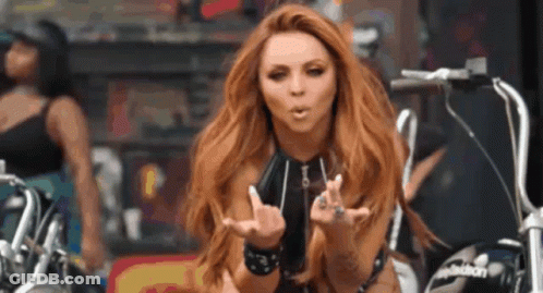 A Woman Blowing A Kiss While Riding A Motorcycle GIF