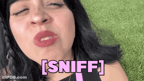 A Woman Blowing A Kiss With The Word Sniff Written In Pink GIF
