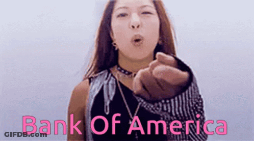 A Woman Blows A Kiss In Front Of A Bank Of America Logo GIF