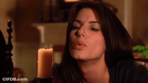 A Woman Blows A Kiss In Front Of A Lit Candle GIF
