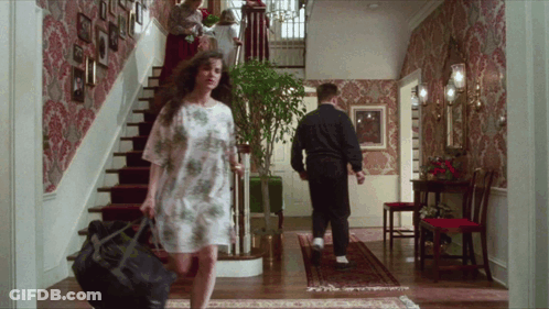 A Woman Carrying A Black Bag Walks Down The Stairs GIF