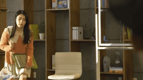 A Woman Carrying A Book That Says ' French ' On It GIF