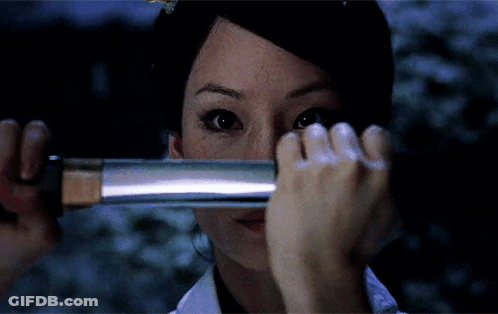 A Woman Covering Her Face With A Sword GIF