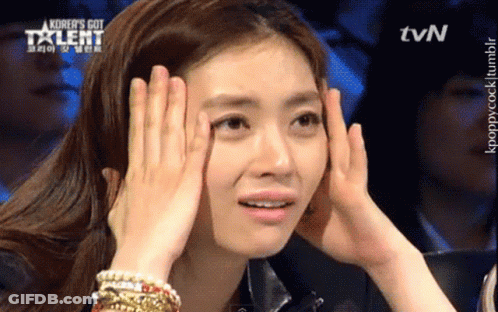 A Woman Covering Her Face With Her Hands With A Tvn Logo Behind Her GIF