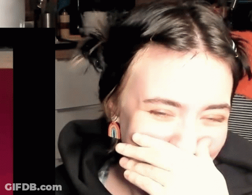 A Woman Covering Her Mouth With Her Hand While Laughing GIF