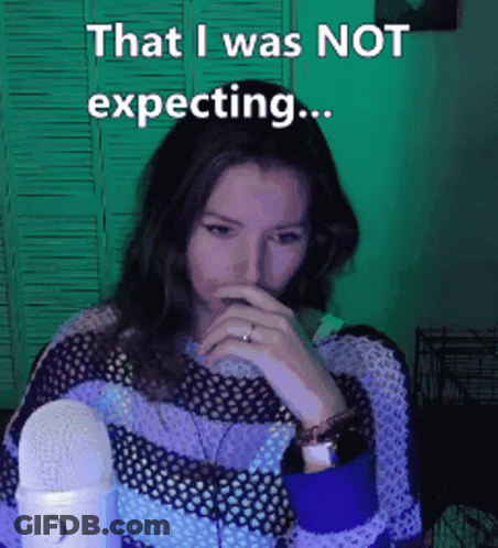 A Woman Covering Her Mouth With Her Hand While Sitting In Front Of A Microphone . GIF