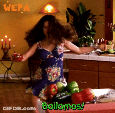 A Woman Dancing In A Kitchen With The Words Bailamos GIF