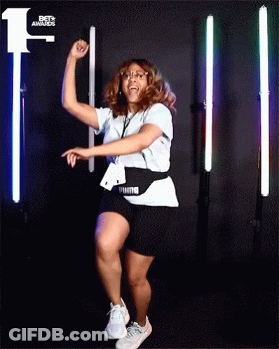 A Woman Dancing In Front Of A Bet Awards Sign GIF