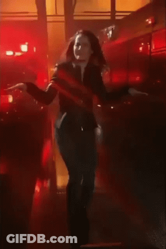 A Woman Dancing In Front Of A Fire Truck GIF