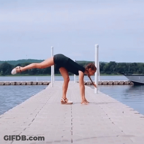 A Woman Doing A Split On A Dock Next To A Boat GIF