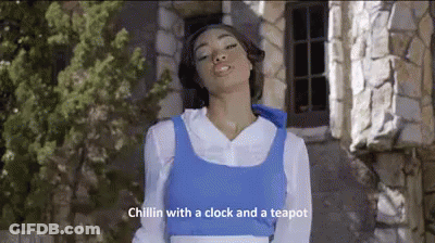 A Woman Dressed As Belle From Beauty And The Beast Is Standing In Front Of A Stone Building With Her Eyes Closed . GIF