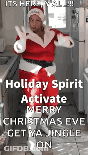 A Woman Dressed As Santa Claus Is Dancing In A Kitchen GIF