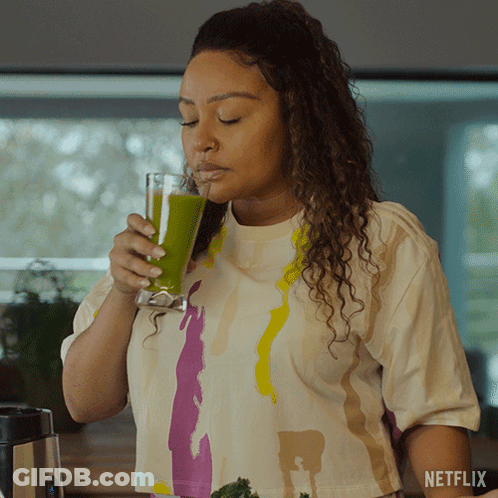 A Woman Drinking A Green Smoothie With A Netflix Logo On The Bottom GIF