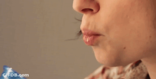 A Woman Drinking From A Blue Cup With Her Mouth Open GIF