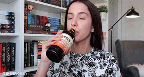 A Woman Drinking From A Bottle That Says Brew On The Label GIF