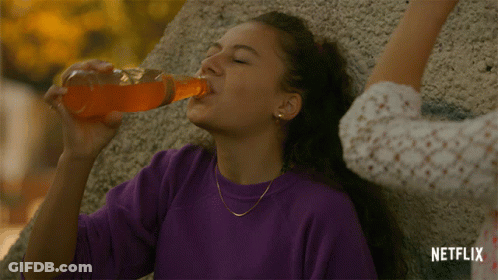 A Woman Drinking From A Bottle With A Netflix Logo On The Bottom GIF