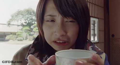 A Woman Drinking From A Small White Cup GIF
