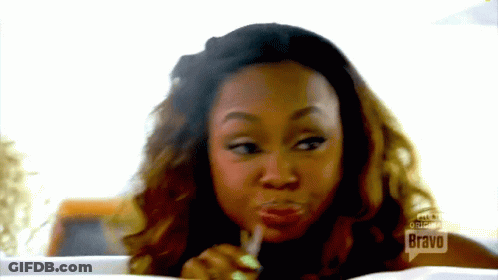 A Woman Eating A Piece Of Food With Bravo Written On The Bottom GIF