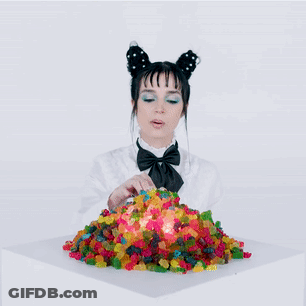 A Woman Eating A Pile Of Gummy Bears GIF