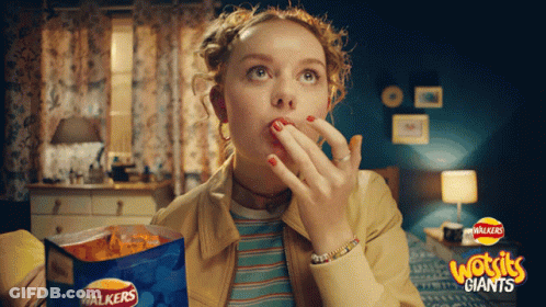 A Woman Eating Walkers Giants Chips In A Room GIF