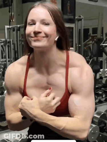 A Woman Flexes Her Muscles In A Gym GIF