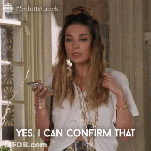 A Woman From Schitts Creek Is Holding A Cell Phone And Saying Yes I Can Confirm That GIF