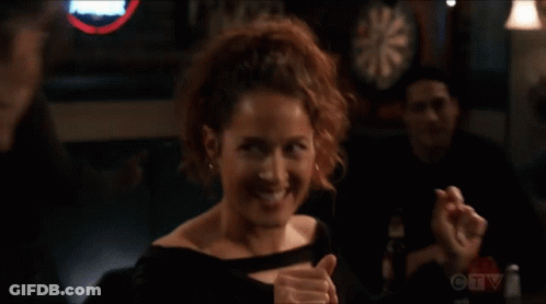 A Woman Giving A Thumbs Up In Front Of A Dart Board On Ctv GIF