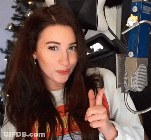 A Woman Giving A Thumbs Up In Front Of A Microphone . GIF