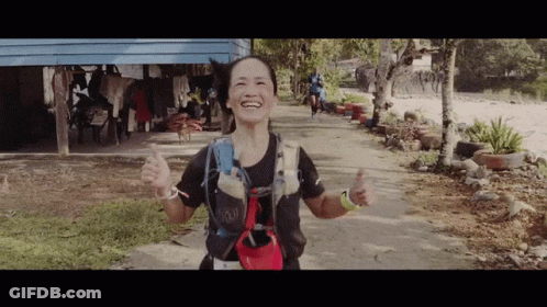 A Woman Giving A Thumbs Up While Wearing A Backpack With The Word Buff On It GIF