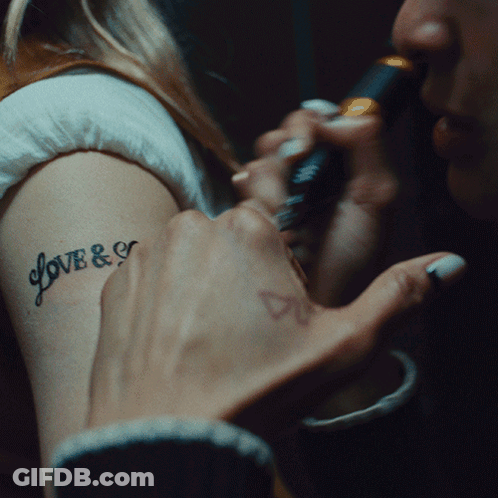 A Woman Has A Tattoo On Her Arm That Says Love & E GIF
