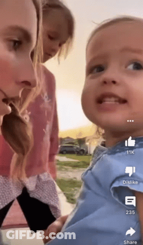 A Woman Holding A Baby With A Thumbs Up And Dislike Buttons On The Bottom GIF