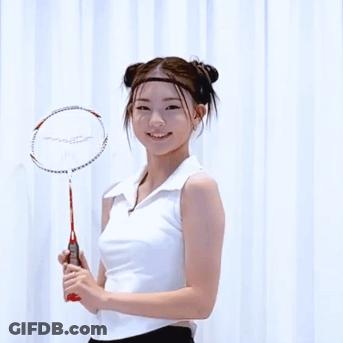 A Woman Holding A Badminton Racket With The Word Slazenger On The Handle GIF