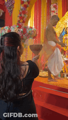 A Woman Holding A Bowl In Front Of A Man GIF