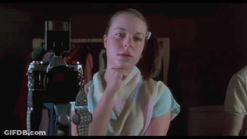 A Woman Holding A Camera With The Words " This Is Looking Really Good " Above Her GIF