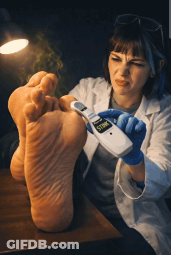 A Woman Holding A Device That Says Stink On The Screen GIF