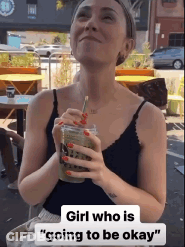 A Woman Holding A Drink With The Words Girl Who Is Going To Be Okay On The Bottom GIF