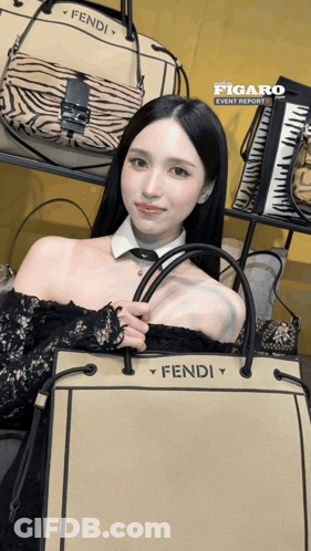 A Woman Holding A Fendi Purse In Front Of A Display Of Handbags GIF