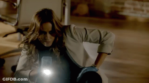 A Woman Holding A Flashlight In Her Hand GIF