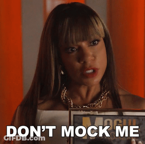 A Woman Holding A Framed Picture With The Words " Do N't Mock Me " On The Bottom GIF